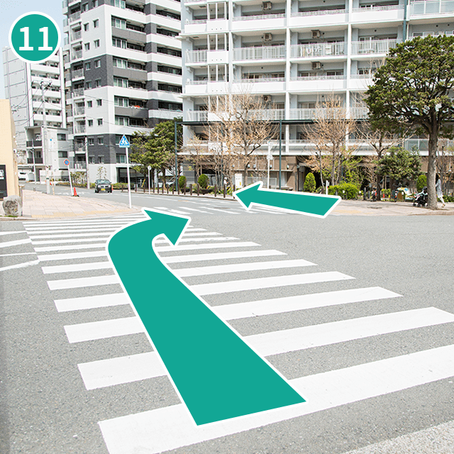 交差点を渡ったら、反対側に行く横断歩道を渡って矢印方向に直進してください。